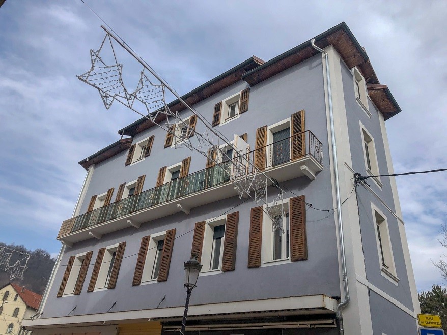 rénovation immeuble Gambeta avec pose d'une isolation thermique extérieure à Albertville. L'immeuble est dans les tons bleus mauve avec volets en bois chêne foncé