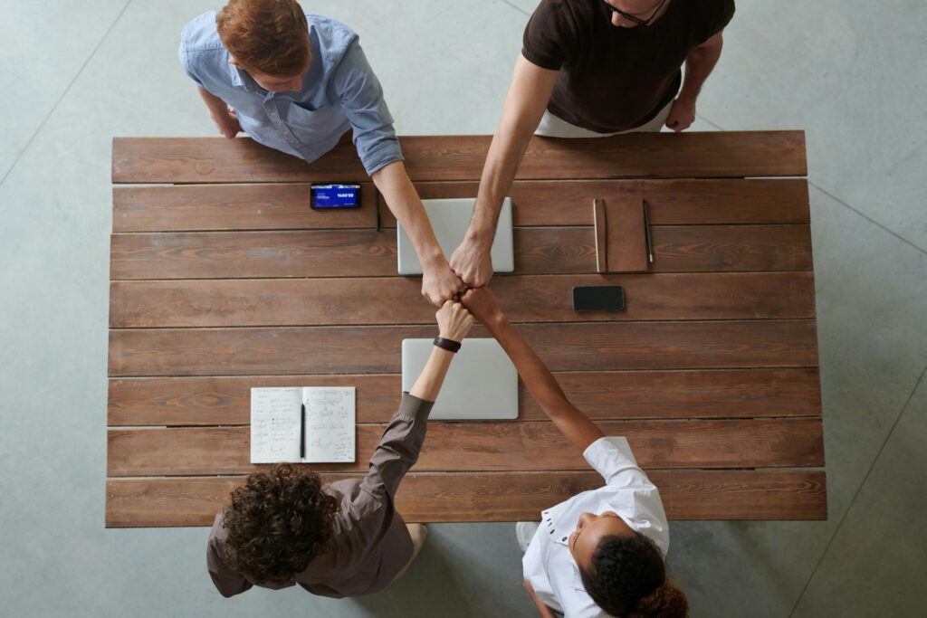 Une vue de dessus d'une équipe de nos partenaires qui joignent leurs mains sur une table